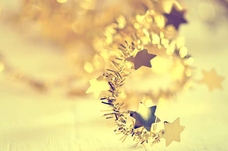 Blurry stylised Christmas decoration vintage background with golden stars. Selective focusの写真素材