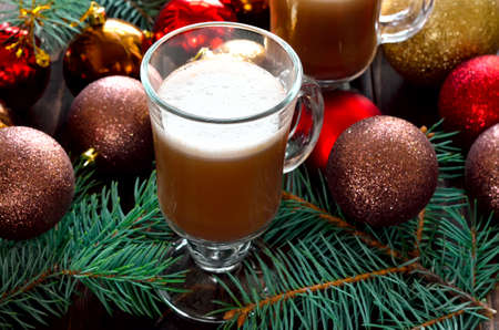 Cocoa or coffee with milk in glass cups with christmas decorationの写真素材