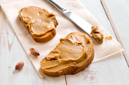 Peanut butter sandwiches or toasts  on light wooden background