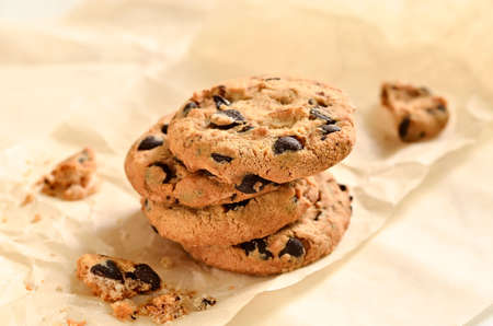 Homemade chocolate chips crispy cookies on baking paper in a morning light