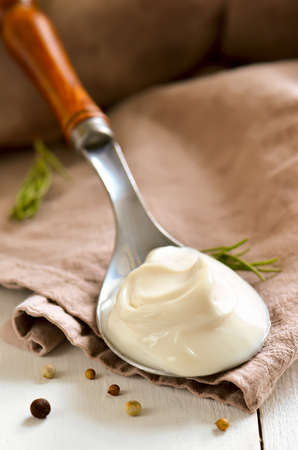 Mayonaisse in a spoon on a rustic napkinの写真素材