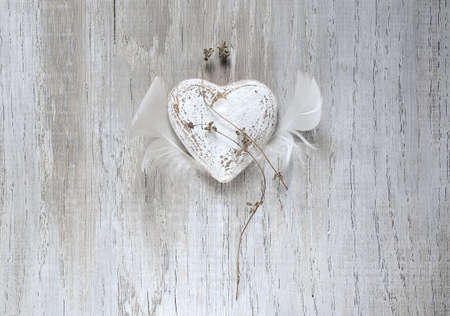 Grunge rustic Valentine heart with feather wings. Long lasting love simbolの写真素材