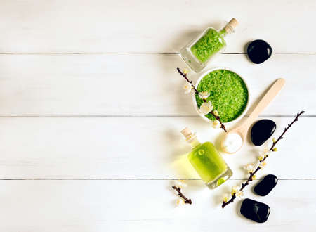 Spa set with sea salt, essencial oil and stones decorated with spring blooming branchesの写真素材