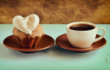 Retro stylized photo of muffin with a cup of coffee for breakfastの写真素材