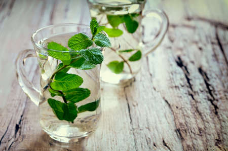 Stylized photo of two cups with fresh mint tea