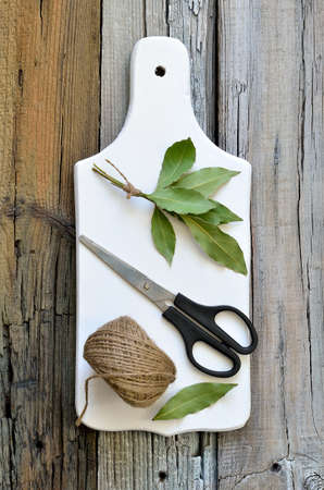 Bunch of bay leaves on a white kitchen boardの写真素材