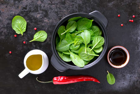Fresh spinach leaves with salad dressings, cooking concept