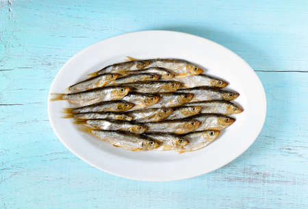 Smoked sprats in an oval white dish, top viewの写真素材