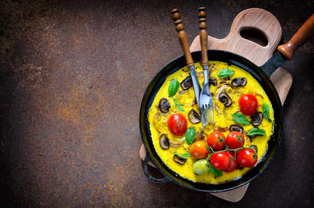 Frittata or omelet with mushrooms and tomatoes in a pan, mediterranian course, top viewの写真素材