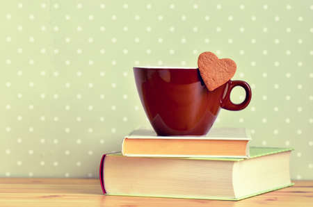 Cup of coffee, cocoa or tea standing on a stack of booksの写真素材
