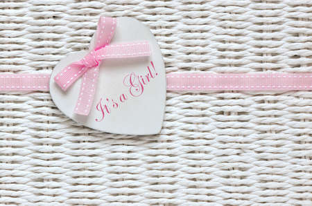 Baby shower card or invitation for baby girl with white wooden decorative heart with text on itの写真素材