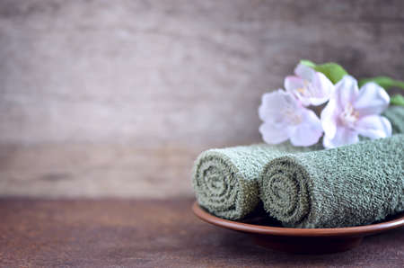 Green towels decorated with spring flowers, spa concept, sylized photoの写真素材