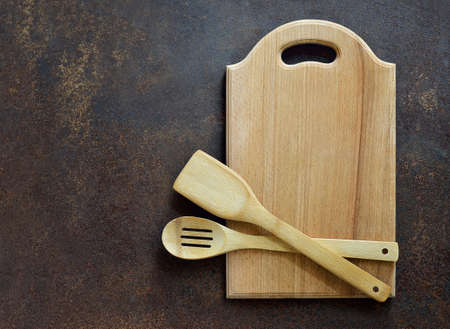 Wooden kitchen utensils on a dark surface, overhead viewの写真素材