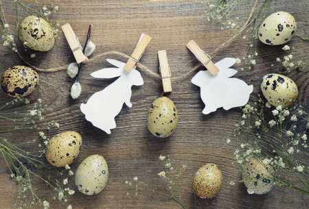 Easter concept with bunnies silhouette and quail eggs on a twine, stylized photoの写真素材