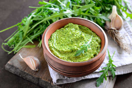 Homemade arugula pesto in a rustic bowlの写真素材