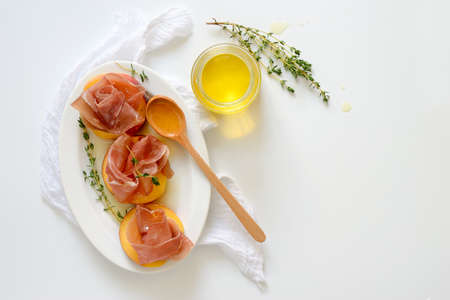 Procsiuto and peach bites with honey and thyme dressing, juicy and simple gourme appetizer