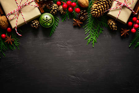 Christmas or New Year dark wooden background, Xmas black board framed with season decorations, space...