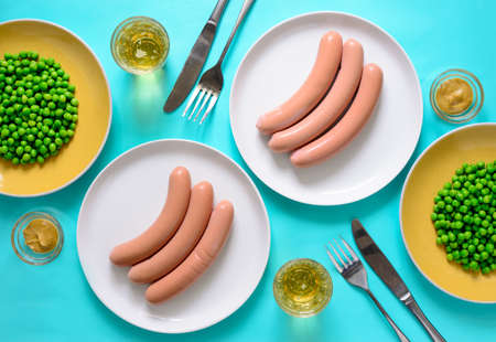 Sausages and beer served with mustard and green peas, view from above table settingの写真素材