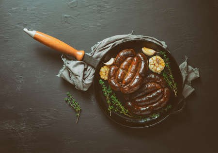 Roasted sausages in a cast iron pan, view from aboveの写真素材
