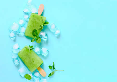 Green refreshing mint ice pop with ice cubes decorated with mint leaves, view from aboveの写真素材