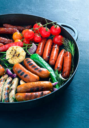Assorted grilled sausages in a pan, close up view, vertical orientationの写真素材
