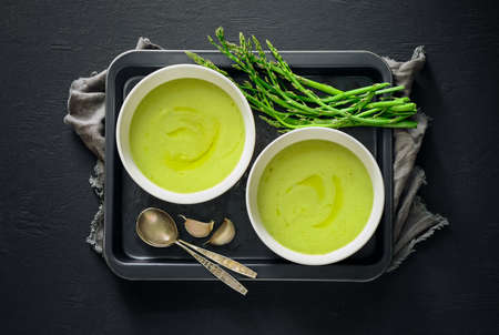 Spring asparagus soup in two bowls, top view