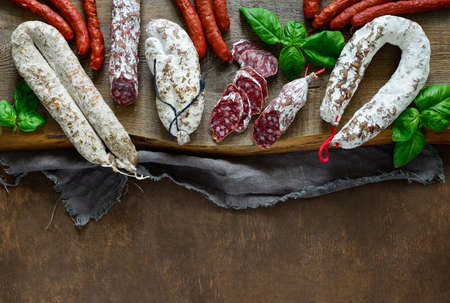 Artisan salami on a rustic board, view from above, flat lay, space for atext