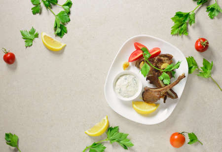 Lamb chops served with tzatziki sauce, flat lay composition of a table setting with a space for a text, overhead viewの写真素材