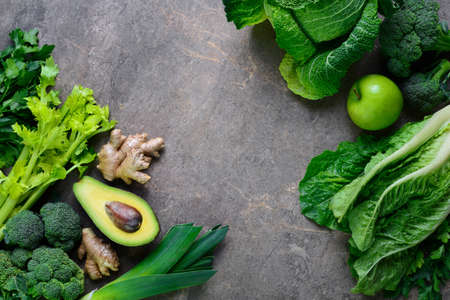 Green fruits and leafy vegetables arrangement simbolising vegetarian or healthy alimentary products for keeping detoxifying or getting skinny diet, flat lay template with blank space for a text, view from aboveの写真素材
