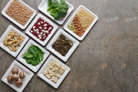 Set of various vegan protein sources, assortment of vegan protein rich alimentary products such as tofu, legumes, nuts, seaweeds and other, view from above, flat lay, space for a textの写真素材