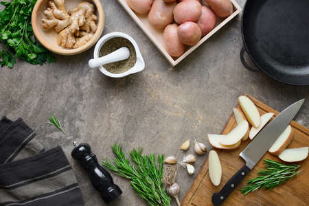 Fresh from the farm potatoes ready to be roasted with garlic and rosemary, culinary concept, flat lay, overhead view, space for a textの写真素材
