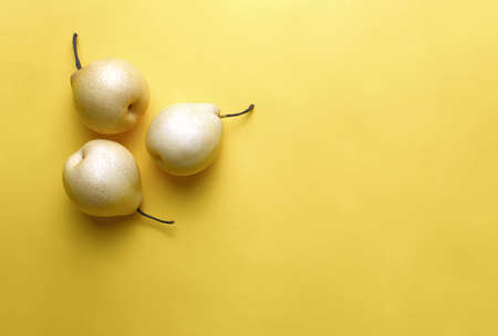 Yellow ripe summer pears on yellow backgrond,  view from above, space for a textの写真素材
