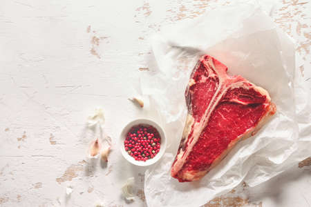 T-bone raw steak on a kitchen table surface, view from above, space for  a textの写真素材
