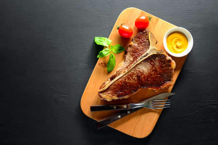 Cooked and ready to eat T-bone steak served on a board, flat lay, view from above, space for a textの写真素材