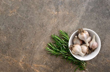 Culinary background with rosemary and garlic, flat lay, overhead view, space for a textの写真素材
