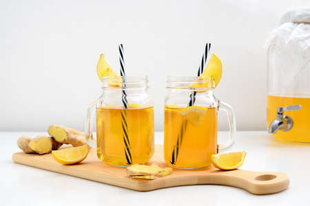 Ginger and lemon combucha detox drink in two jars with straws, front viewの写真素材