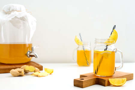 Ginger and lemon combucha detox drink in two jars with straws, front view, space for a textの写真素材