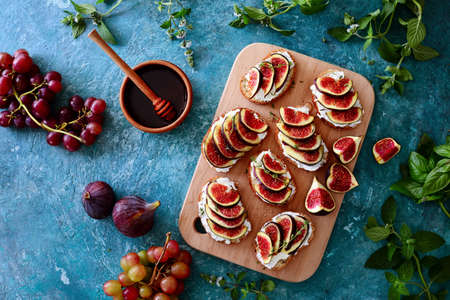 Open faced sandwiches with goat cheese and figs with thyme and honey dressing, view from above