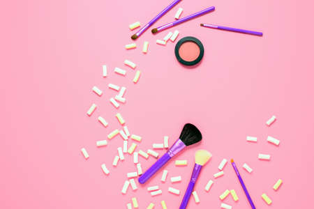 Make up cosmetic stuff is lying on a pink background with marshmallows around , flat lay, blank space for a textの写真素材