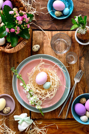 Easter table setting, holiday table home decor idea, flat lay composition with cutlery, Easter eggs and fresh flowersの写真素材