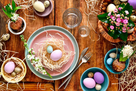 Easter table setting, holiday table home decor idea, flat lay composition with cutlery, Easter eggs...