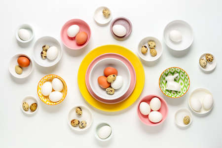 Easter home decor concept, view from above on various types of plates and bowls filled with natural eggsの写真素材
