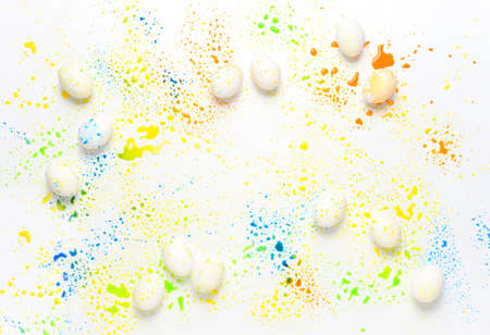 Easter greeting card background with wet paint splashes over Easter eggs, flat lay composition with a space for a textの写真素材