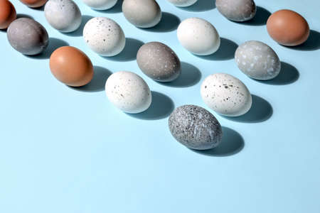 Easter eggs minimal concept, flat lay of naturally painted eggs lying diagonally, with strong sunshine shadowの写真素材