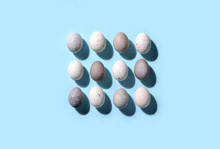 Easter eggs minimal concept, flat lay of naturally painted eggs lying in line, with strong sunshine shadowの写真素材