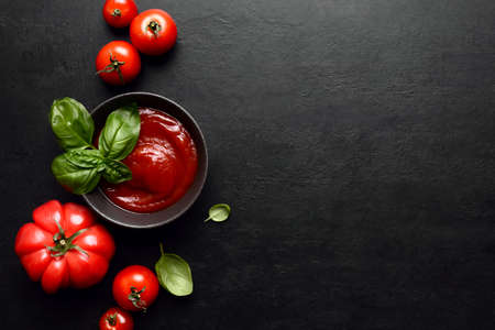 Tomato sauce or ketchup culinary concept, dark  food background with blank space for a text, top down viewの写真素材