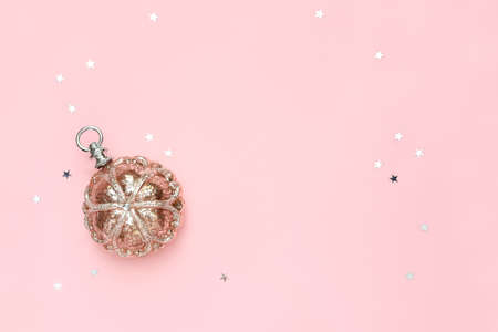 Christmas background with copy space for a greeting text, flat lay composition of X-Mas tree decoration and glittering stars lying down on pink empty surfaceの写真素材