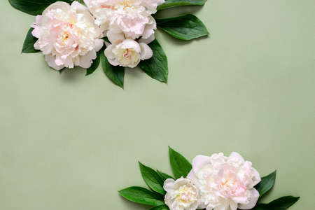 Mother's Day card or wedding invitation card with blooming peonies lying down on green surface,...