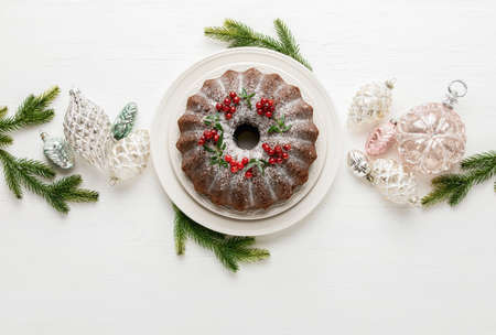 Christmas bundt cake served on white wooden table and decorated with Xmas holiday decorations, top down view, blank space for a greeting textの写真素材
