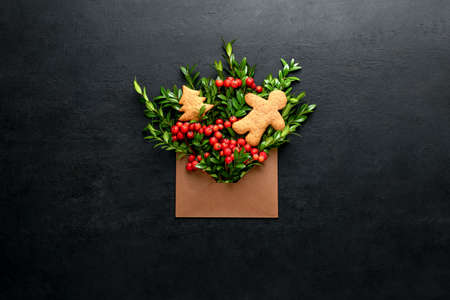 Christmas greeting card minimalist concept, open envelope with holiday natural botany decorations, ...